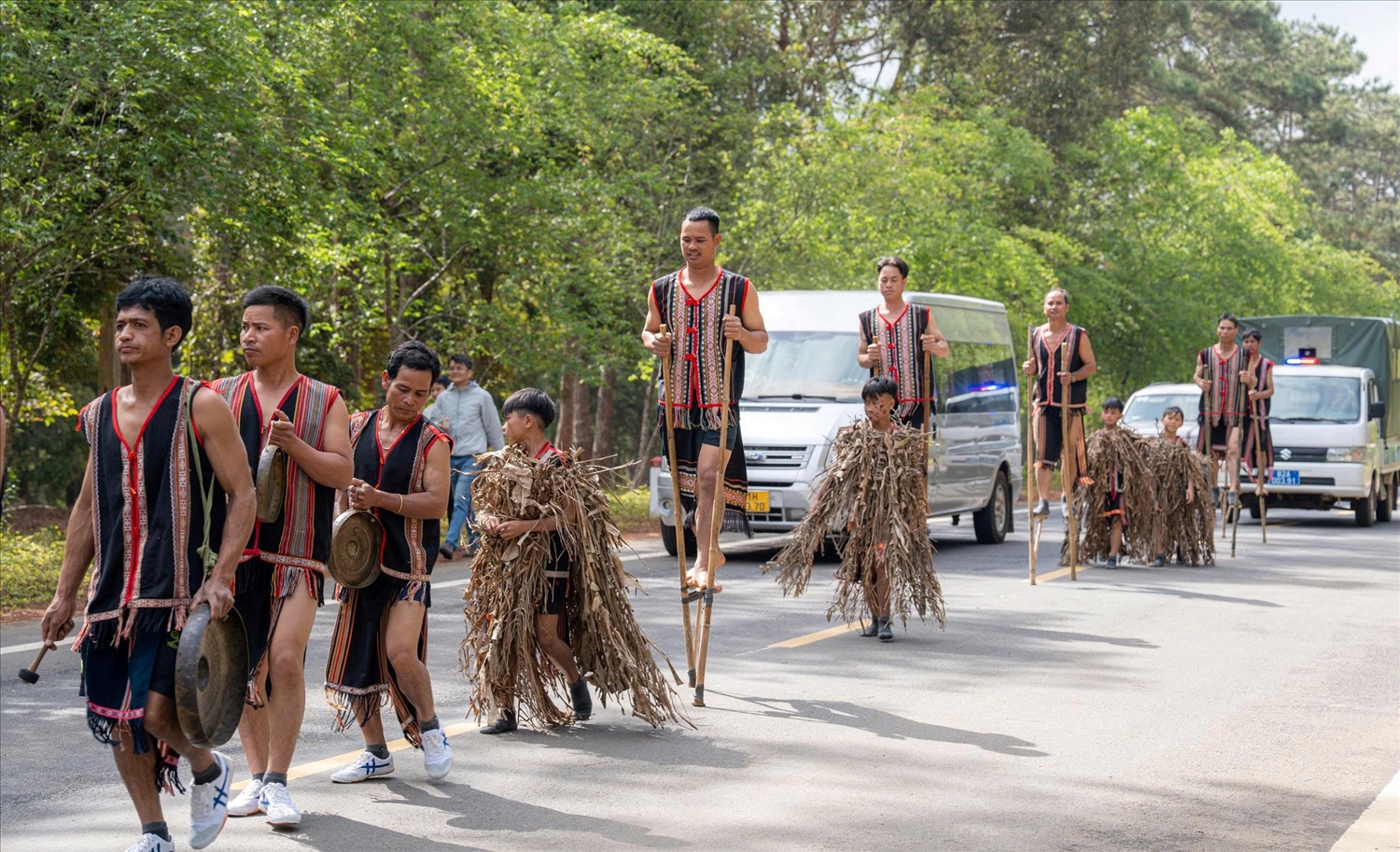 Các nghệ nhân trình diễn cồng chiêng và đi cà kheo dọc tuyến đường dài gần 3 km. (Ảnh: N.C)