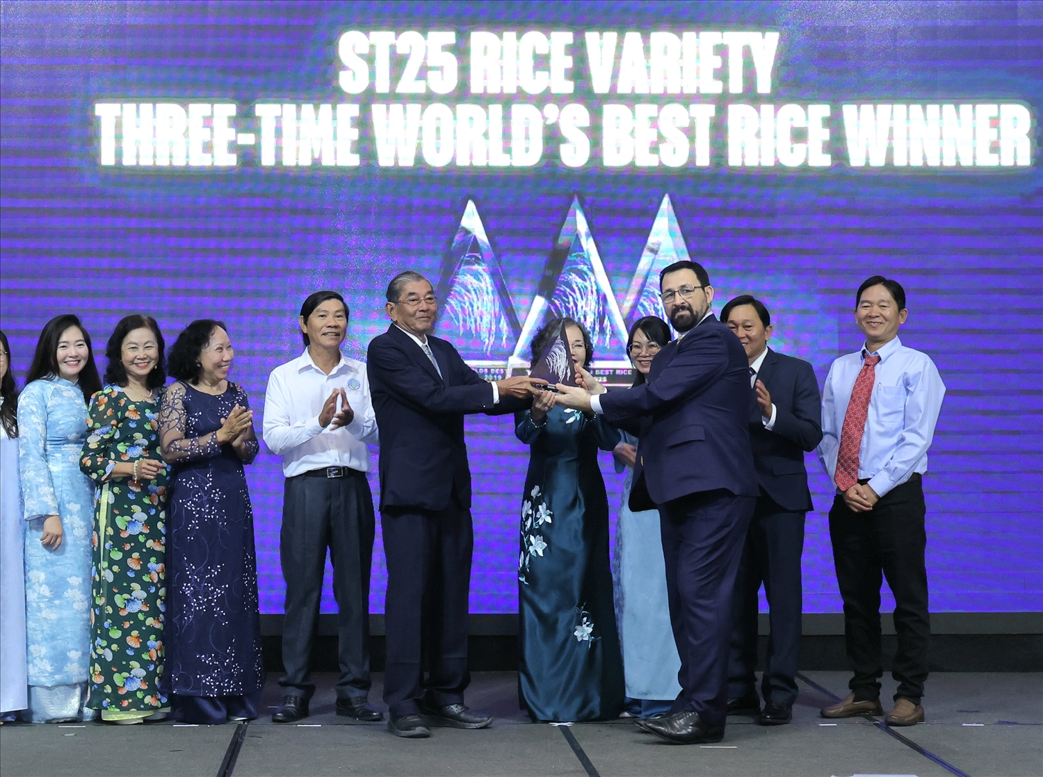 Tổ chức The Rice Trader trao cúp 'Gạo ngon nhất thế giới' năm 2025 cho gạo Ông Cua ST25 của Việt Nam, vinh danh Anh hùng lao động Hồ Quang Cua (cầm cúp bên trái) cùng nhóm tác giả. (Ảnh: Trung Phạm)