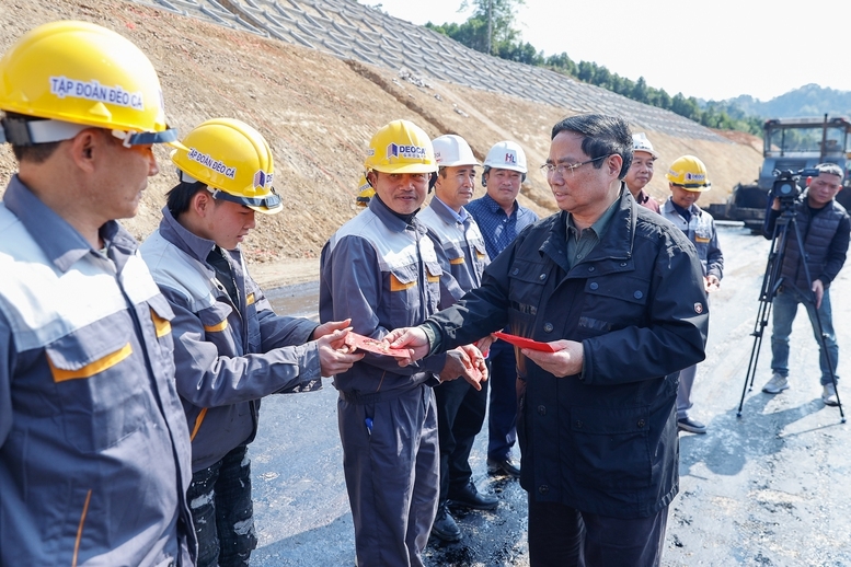 Thủ tướng tặng quà công nhân thi công tại Km43 dự án Đồng Đăng - Trà Lĩnh - Ảnh: VGP/Nhật Bắc