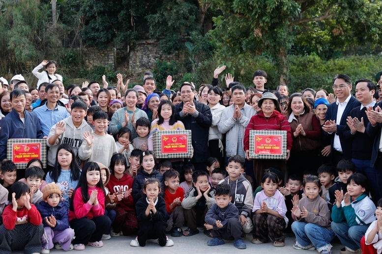 Thủ tướng tặng quà các gia đình trong khu tái định cư - Ảnh: VGP/Nhật Bắc