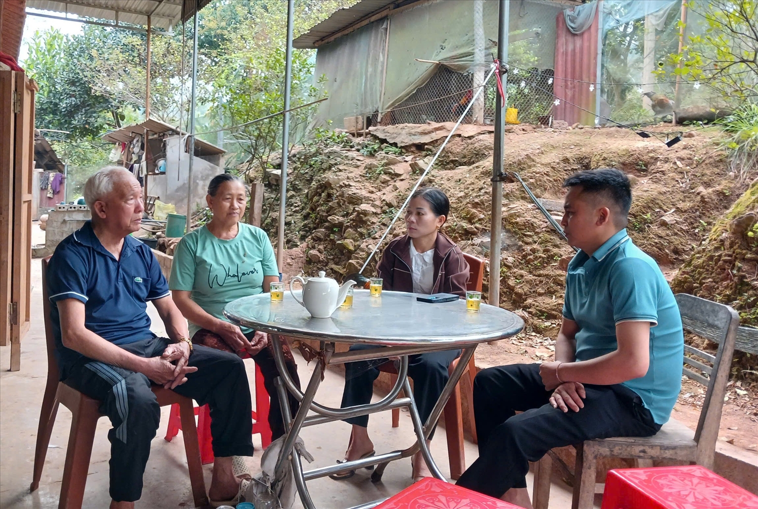 Cụ Lô Thanh Định và vợ là cụ Lô Thị Tím (bìa trái) kể về việc tự nguyện nộp đơn xin thoát nghèo - Ảnh: T.H