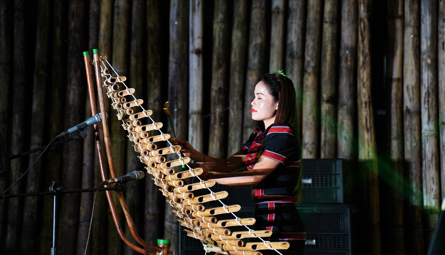 Cô gái Xơ Đăng trình diễn đàn Tơ rưng phục vụ du khách tại không gian Chợ phiên Măng Đen