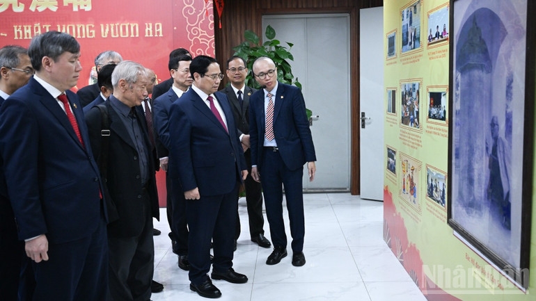 Thủ tướng Phạm Minh Chính nghe giới thiệu về quá trình phát triển của Viện Hàn lâm Khoa học xã hội Việt Nam. (Ảnh: TRẦN HẢI)