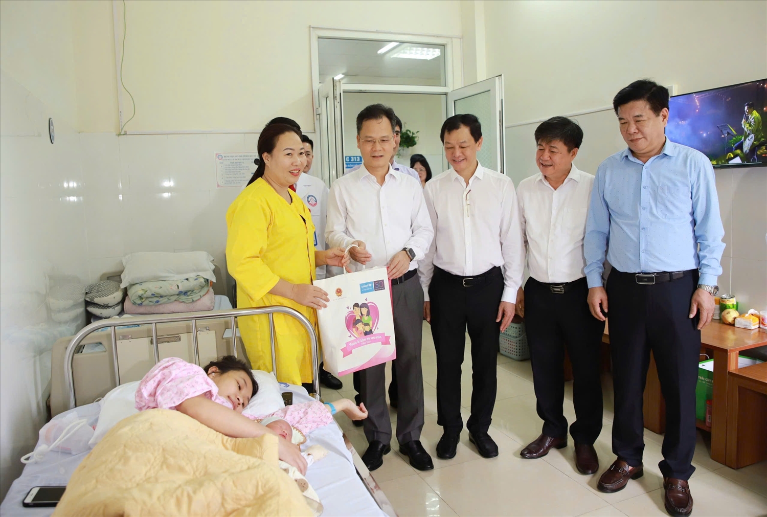 Phó Chủ tịch UBND tỉnh Lào Cai Nguyễn Thành Sinh (thứ 4 từ phải qua) tặng quà bà mẹ, trẻ em đang điều trị tại Bệnh viện Sản nhi Lào Cai nhân Lễ phát động Tuần lễ Làm mẹ an toàn năm 2025 (Ảnh Trọng Bảo)