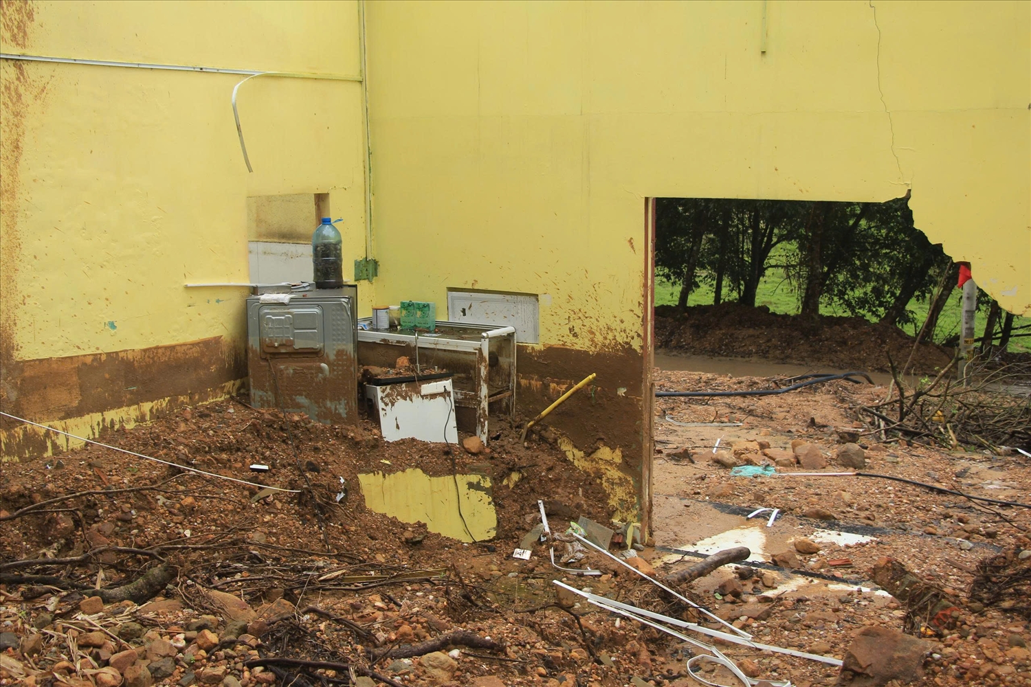 Đất đá từ vụ sạt lở hồi cuối tháng 10/2025 vùi lấp nhiều vật dụng trong nhà bà Hồ Thị Lãnh. (Ảnh NT)