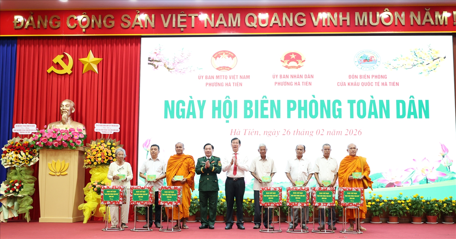 Phó Chủ tịch UBND tỉnh An Giang Lê Văn Phước và Đại tá Nguyễn Văn Hiệp, tặng quà cho người có uy tín trên địa bàn. 
