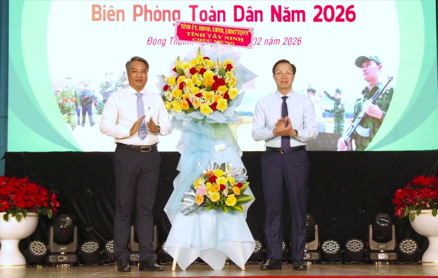 Phó Chủ tịch UBND tỉnh Tây Ninh Đoàn Trung Kiên (bên phải) tặng hoa chúc mừng Ngày hội Biên phòng toàn dân xã Đông Thành. (Ảnh: LK)