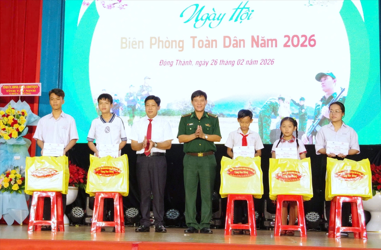 Đại tá Dương Văn Dược, Chính ủy Bộ đội Biên phòng tỉnh Tây Ninh và lãnh đạo xã Đông Thành trao quà và học bổng cho các cháu học sinh. (Ảnh: TĐ)