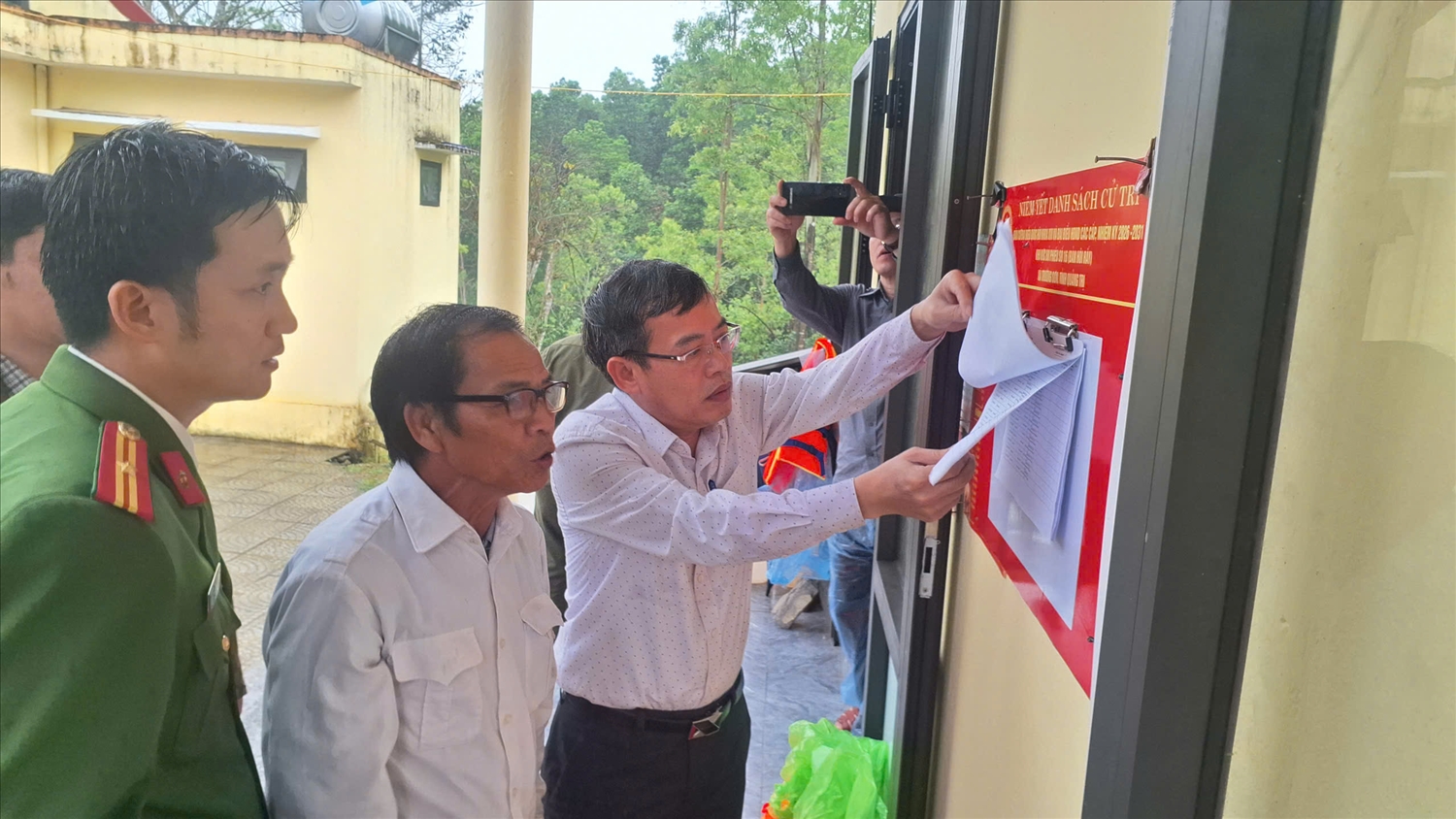 Ông Hoàng Mạnh Hà, chủ tịch UBND xã Trường Sơn (Ngoài cùng bên trái) đi kiểm tra công tác chuẩn bị bầu cử tại bản Hôi Rẫy (Ảnh: Phạm Tiến)