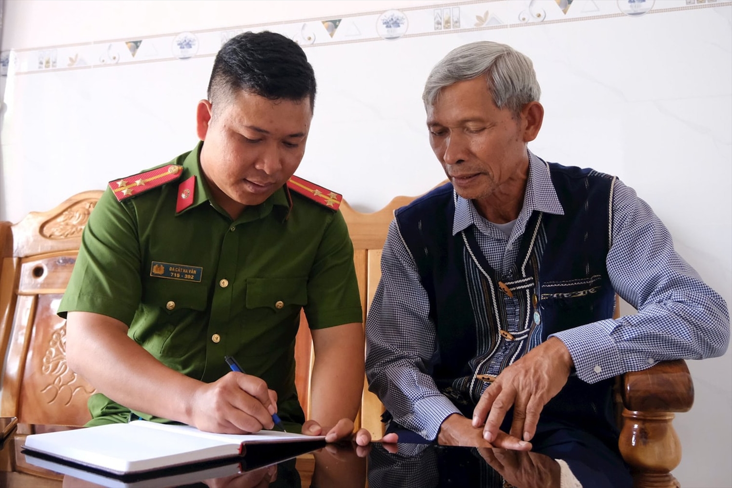 Già làng Đa Cát Tư thường xuyên trao đổi thông tin với công an xã phụ trách khu vực các thông tin liên quan ở thôn Đạ Nhinh 1 (Ảnh: Hồng Thắm)