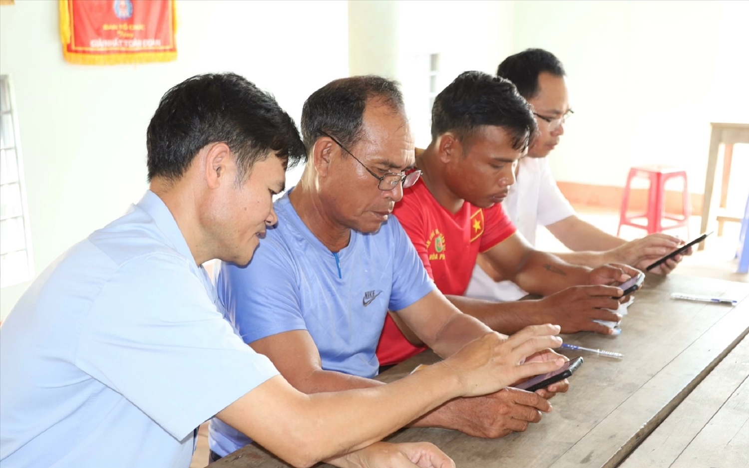 Đảng viên xã Cư Pui tham gia sinh hoạt và hướng dẫn đảng viên Chi bộ buôn T’Liêr sử dụng Sổ tay đảng viên điện tử