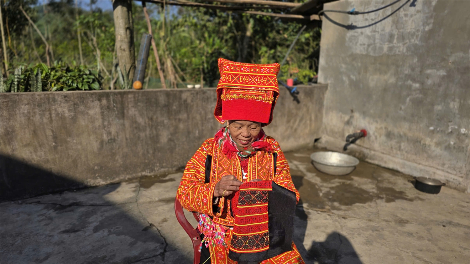 Bà Múi vừa thêu, vừa tự hào khoe vẻ đẹp trang phục dân tộc mình. Ảnh: Mỹ Dung