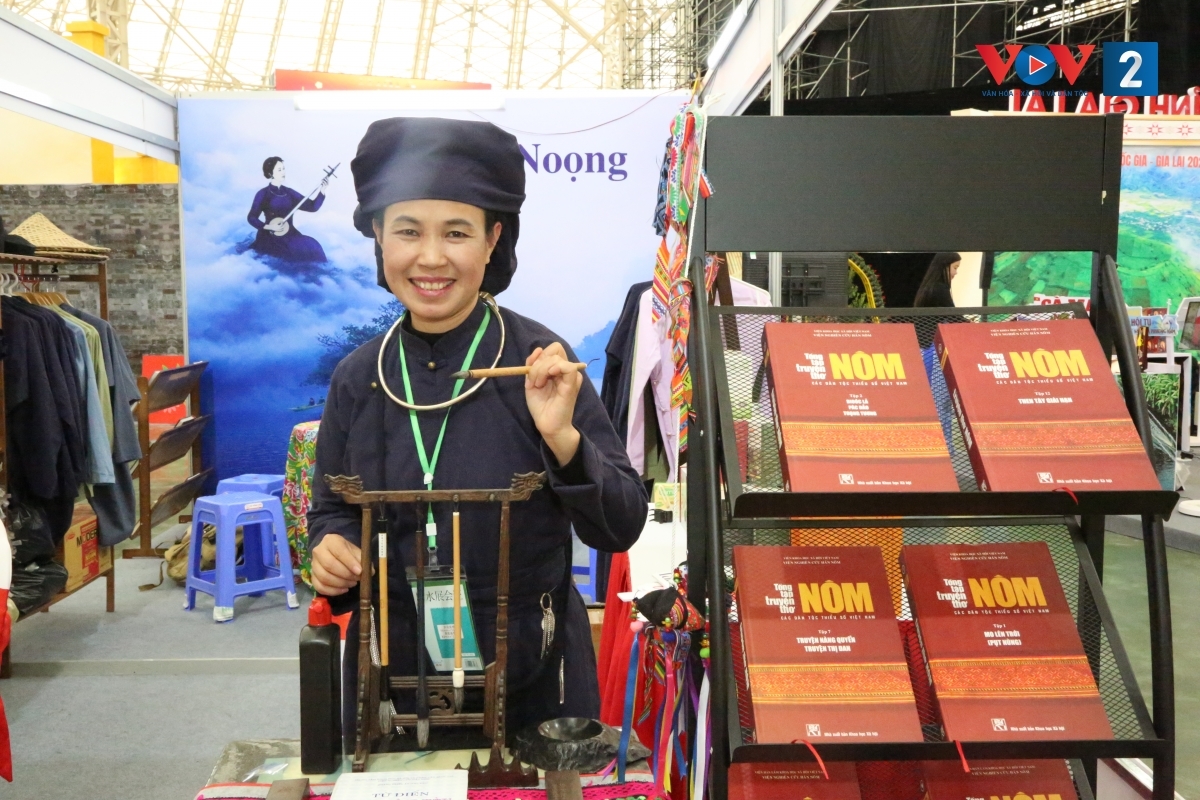 Chị Lý Thị Chiên bên giá bút dùng để viết chữ Nôm và những đầu sách viết về văn hóa Tày