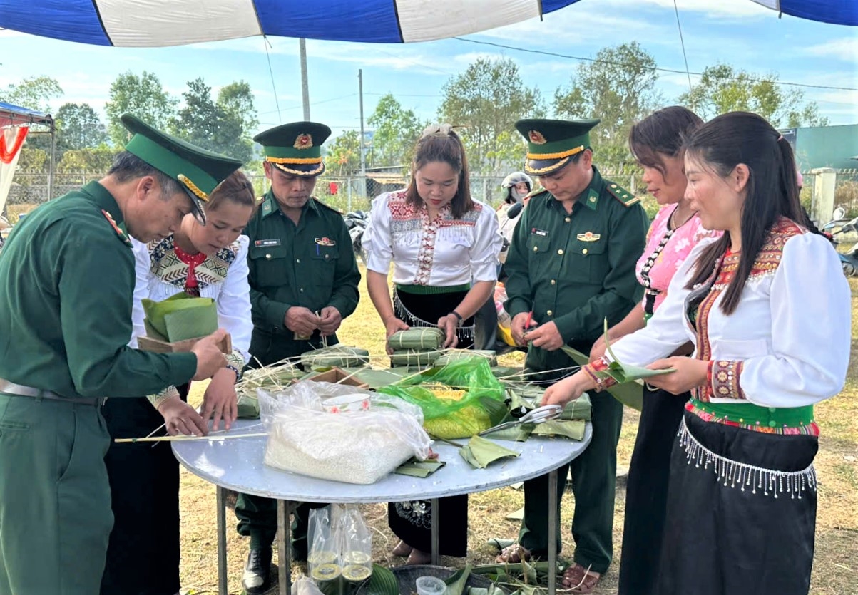 Cán bộ, chiến sĩ Bộ đội Biên phòng cùng tham gia gói bánh chưng với Nhân dân xã biên giới Sa Loong. (Ảnh: Ngọc Chí)