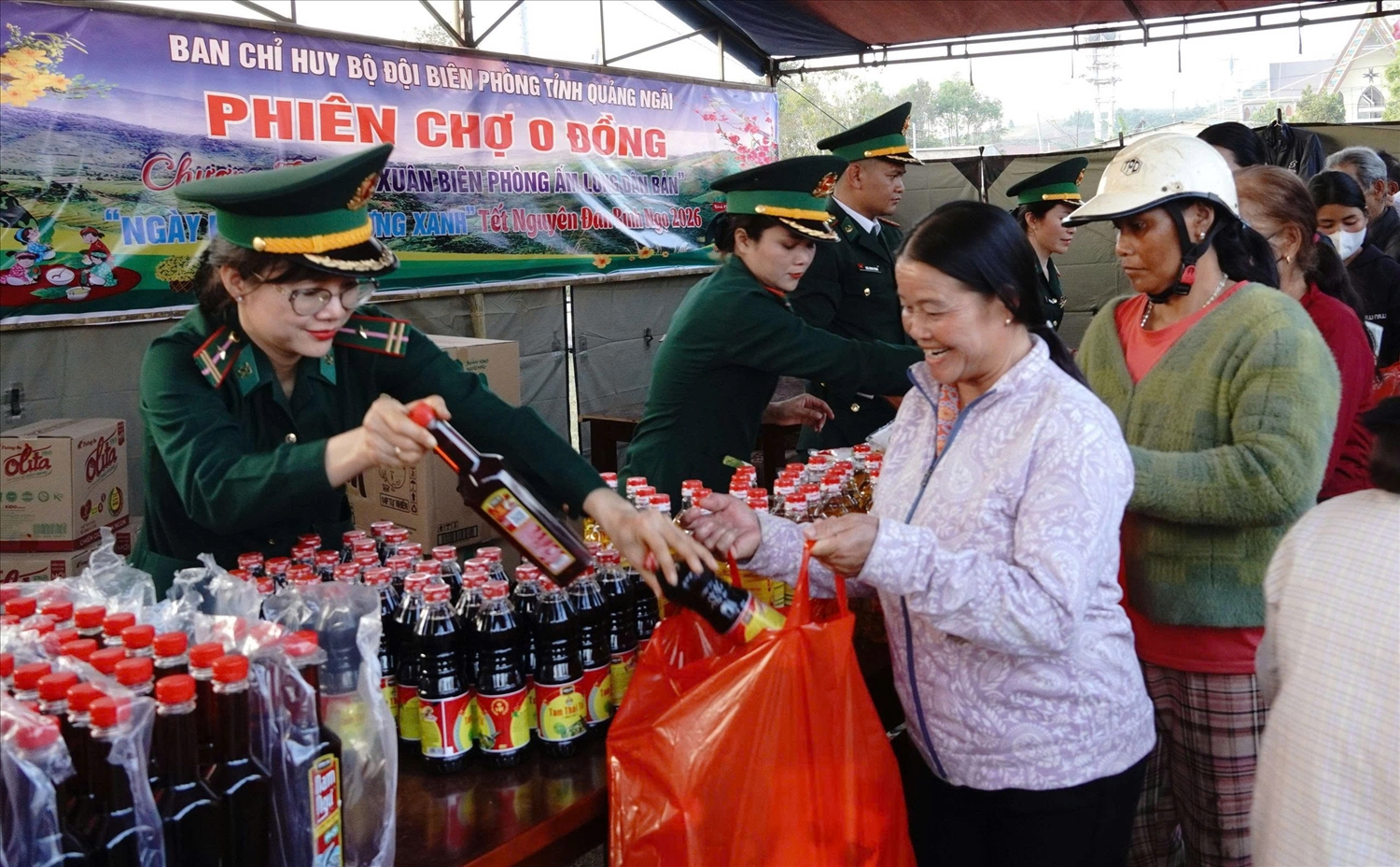 Nhân dân xã biên giới Sa Loong nhận các nhu yếu phẩm từ gian hàng không đồng. (Ảnh: Ngọc Chí)