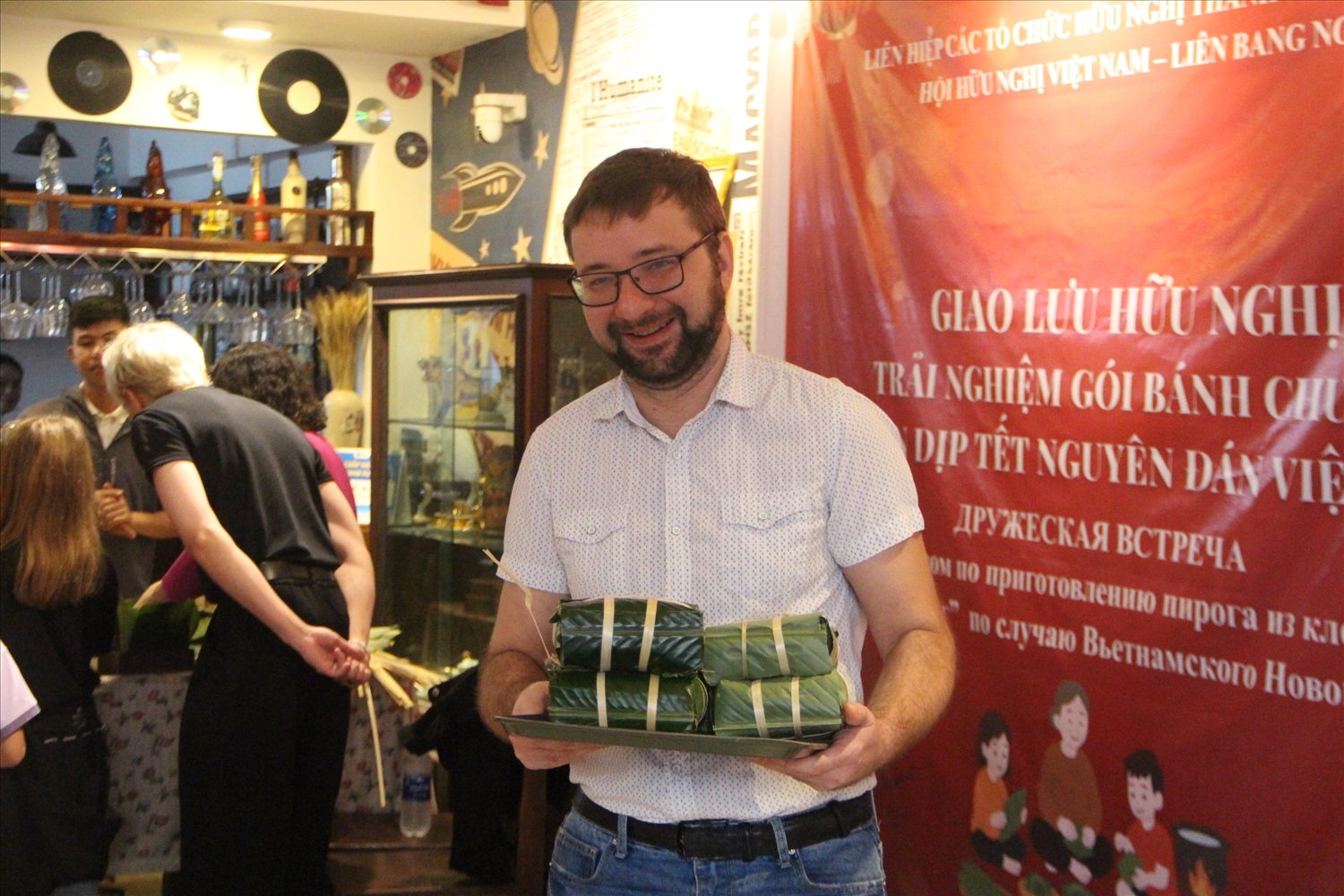 Một người Nga vui mừng giới thiệu thành quả sau khi hoàn thành trải nghiệm gói bánh chưng. (Ảnh TH)