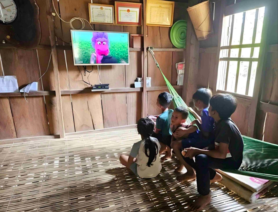 Sau giờ học bài, trẻ em làng Canh Tiến được cha mẹ cho xem phim hoạt hình để giải trí. (Ảnh: T.N)