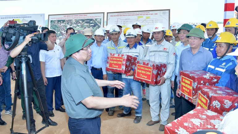Thủ tướng Phạm Minh Chính ân cần nói chuyện, hỏi thăm và mong muốn đội ngũ kỹ sư, công nhân bảo đảm tiến độ, chất lượng công trình. (Ảnh: Thanh Giang)
