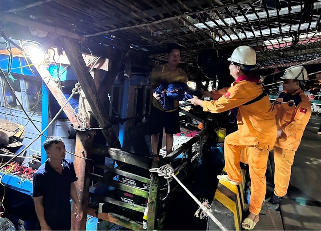 Các thành viên trên Tàu SAR 273 chuẩn bị đưa các ngư dân lên bờ. (Ảnh: ĐVCC)