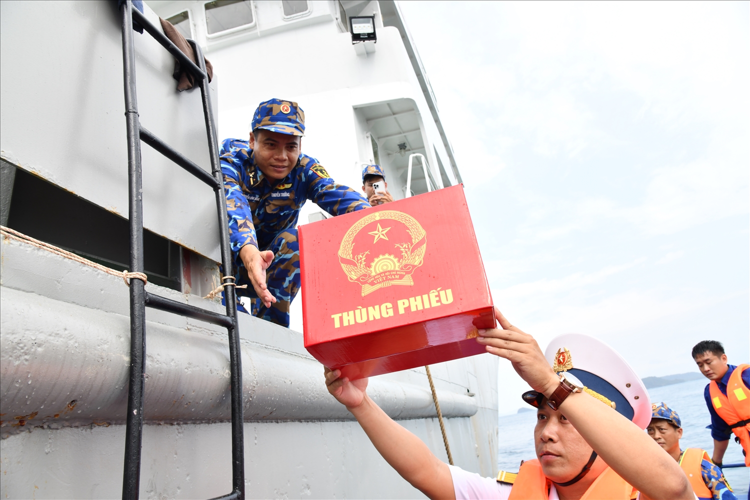 Ngay từ sáng sớm, không khí tại khu vực bỏ phiếu số 60 thuộc Lữ đoàn 127 đã trở nên rộn ràng. (Trong ảnh: Hòm phiếu phụ được đưa lên tàu để cán bộ, chiến sĩ thực hiện quyền công dân) 