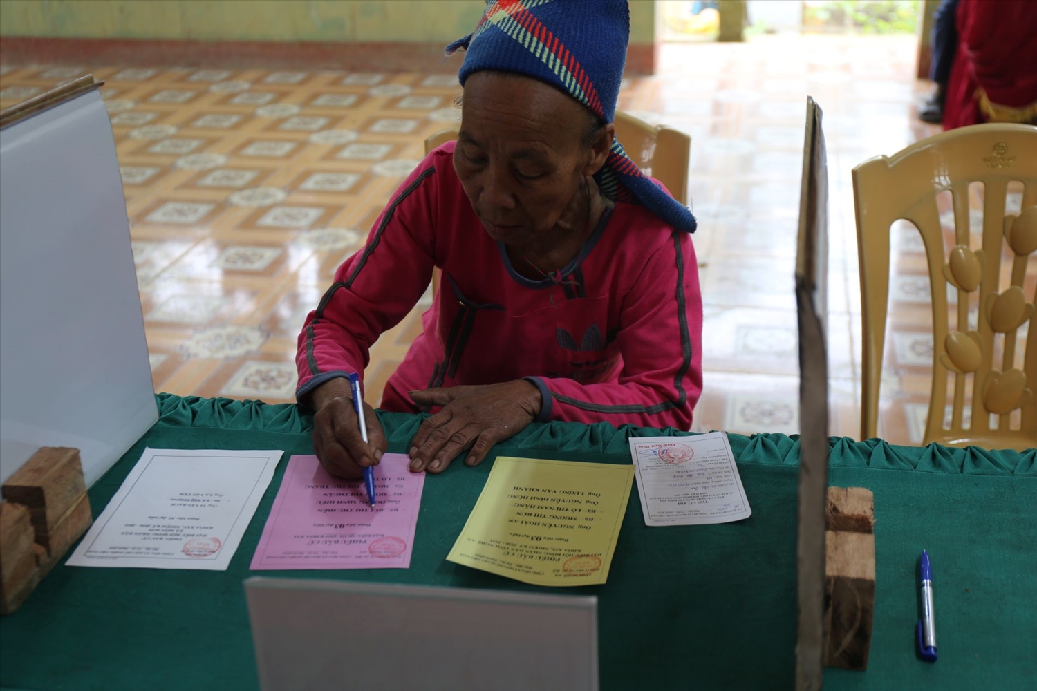 Một người phụ nữ Đan Lai viết phiếu bầu cử. Ảnh: Thanh Hải