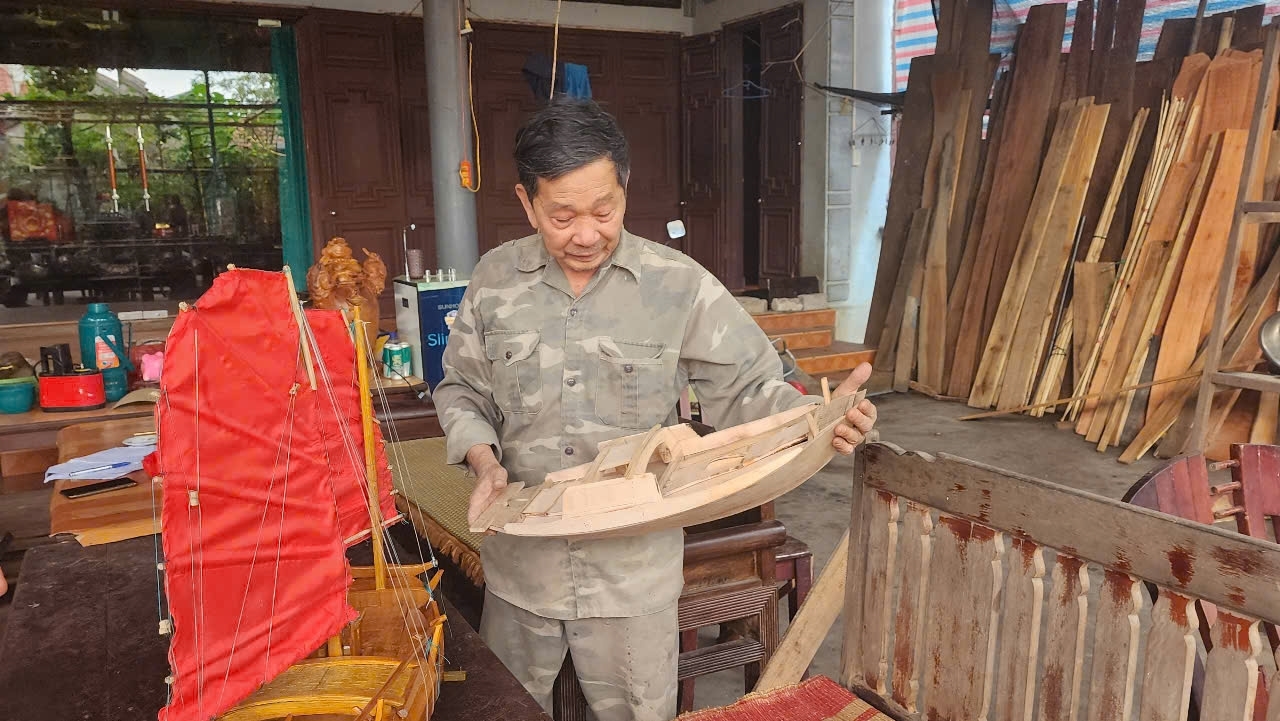 Nghệ nhân Lê Đức Chắn giới thiệu thuyền mô hình để bán cho khách du lịch