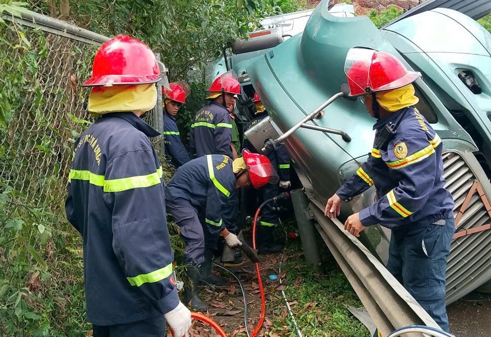 Lực lượng chức năng kịp thời giải cứu tài xế bị mắc kẹt. (Ảnh Công an cung cấp)