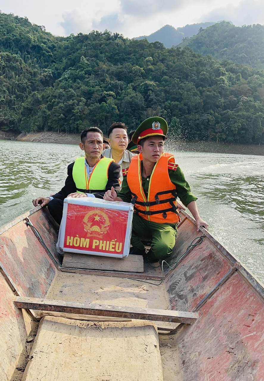 Tổ bầu cử mang hòm phiếu vượt lòng hồ vào điểm bầu cử bản Phia Òi xã Nhôn Mai sáng 15/3 - Ảnh: T.H