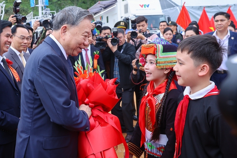 Các em học sinh tại điểm cầu trường phổ thông nội trú tiểu học và trung học cơ sở Đồng Đăng, xã Đồng Đăng, tỉnh Lạng Sơn tặng hoa chào mừng Tổng Bí thư Tô Lâm - Ảnh: VGP/Nhật Bắc