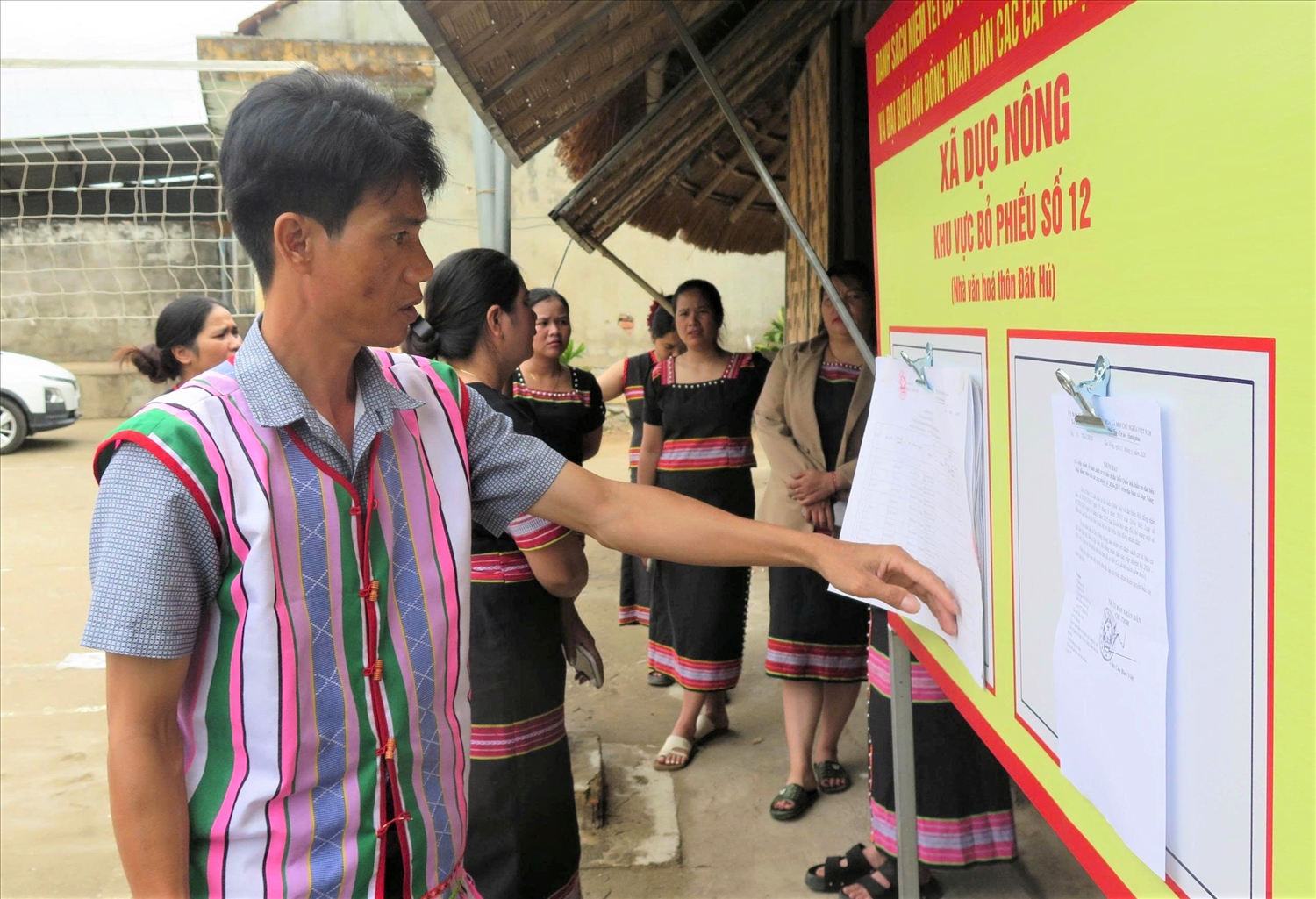 Đồng bào Gié Triêng ở thôn Đăk Hú, xã Dục Nông theo dõi các thông tin về bầu cử đại biểu Quốc hội khóa XVI và HĐND các cấp được niêm yết tại nhà rông của thôn. (Ảnh: Ngọc Chí)