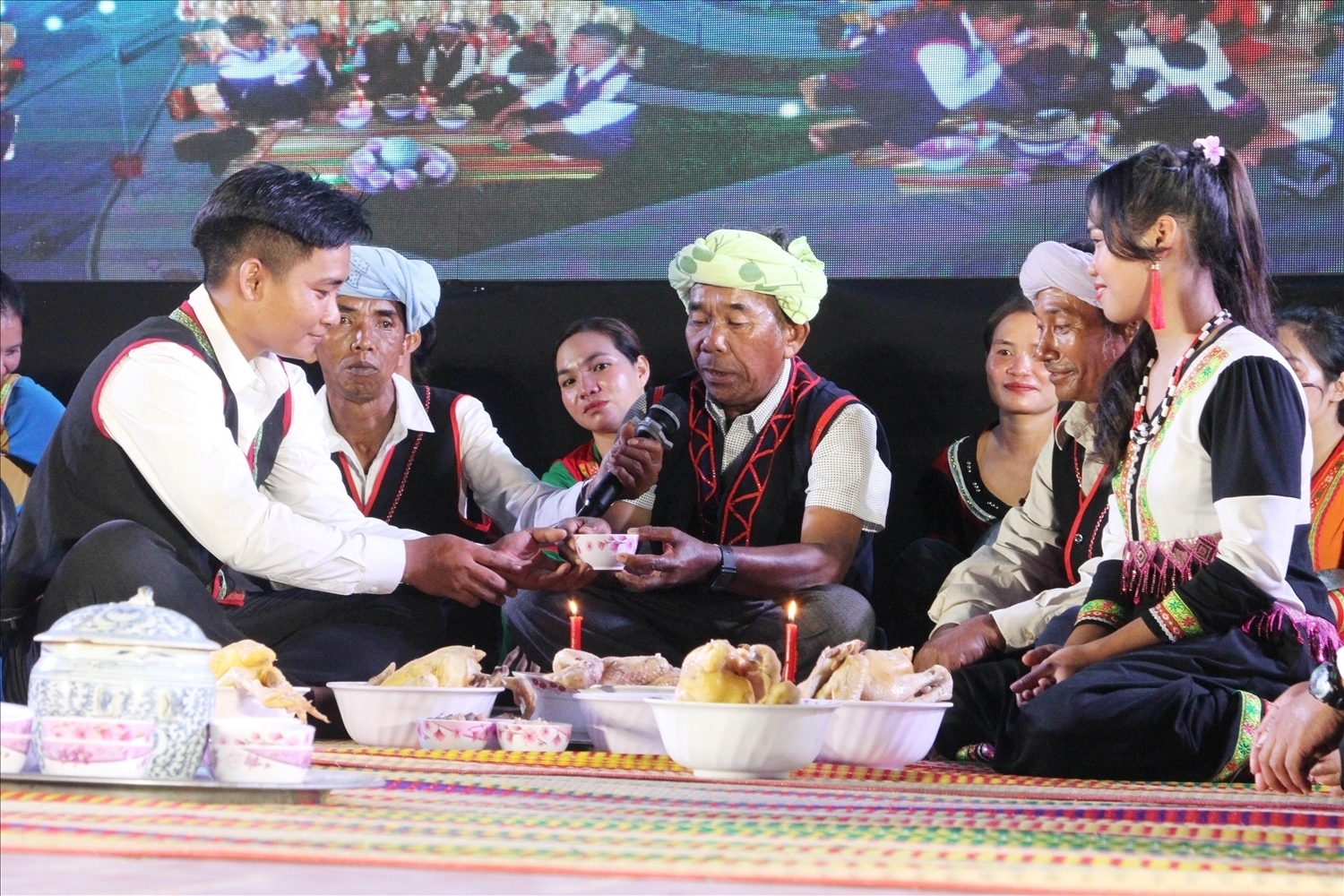 Người có uy tín - Nghệ nhân Ưu tú Pi Năng Trách thực hiện nghi thức trao rượu cần cho chú rể trong Lễ cưới của đồng bào Raglay. (Ảnh: Thái Sơn Ngọc)