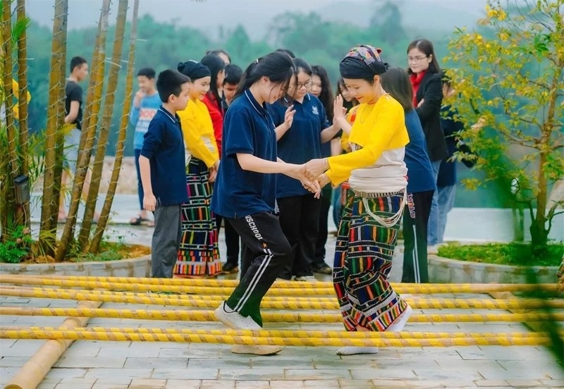 Du khách trải nghiệm nhảy sạp – trò chơi dân gian đặc sắc của đồng bào dân tộc Thái tại bản Mạ, xã Thường Xuân. 