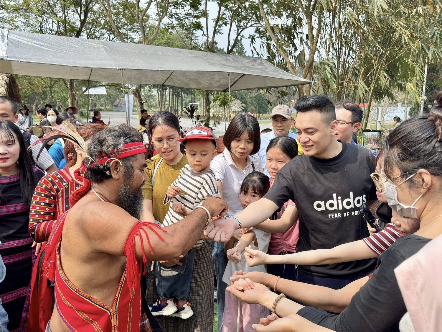 Du khách thăm quan thích thú được chủ lễ buộc chỉ tay