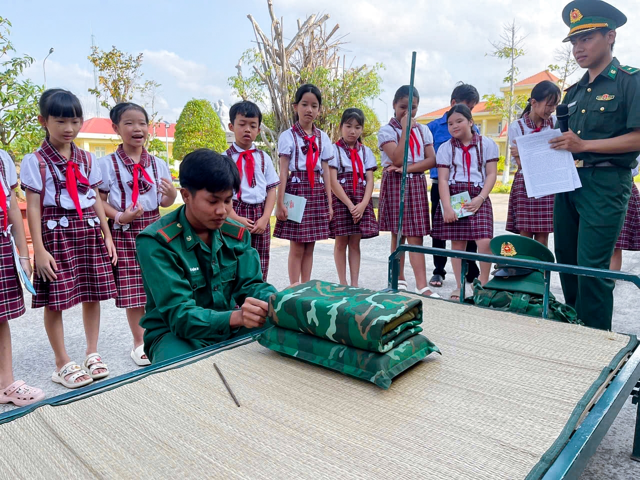 Các em học sinh tham quan trải nghiệm hoạt động sắp xếp nội vụ (đồ dùng cá nhân) của cán bộ, chiến sĩ đồn Biên phòng An Thạnh Ba