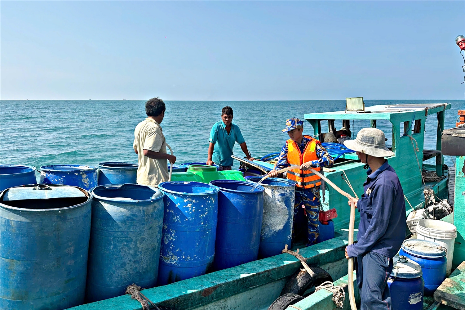 Người dân đảo Hòn Chuối sử dụng thùng phuy vận chuyển nước từ Tàu 527 lên đảo. (Ảnh: Định Thắng)