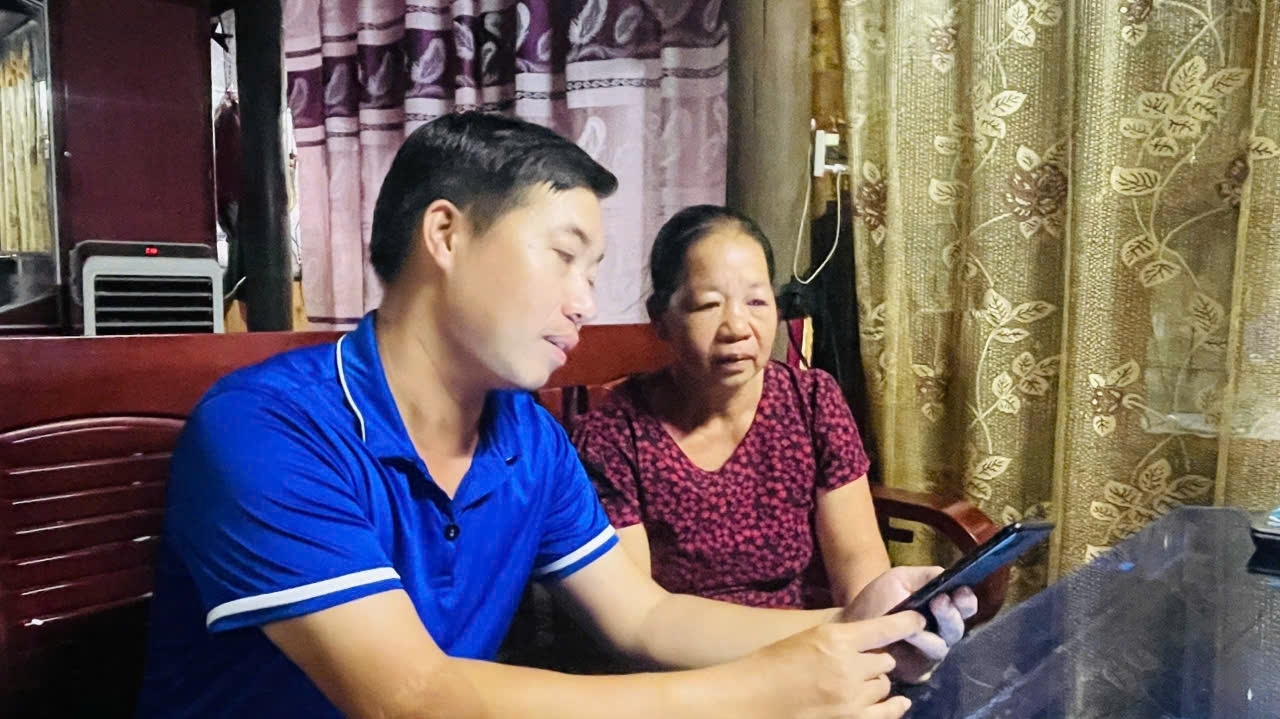 Ông Cao Tiến Viện, Trưởng thôn Tân Lợi, xã Minh Hóa - Thành viên Tổ chuyển đổi số xuống tận hộ gia đình hướng dẫn bà con cập nhập thông tin (Ảnh: Phạm Tiến)