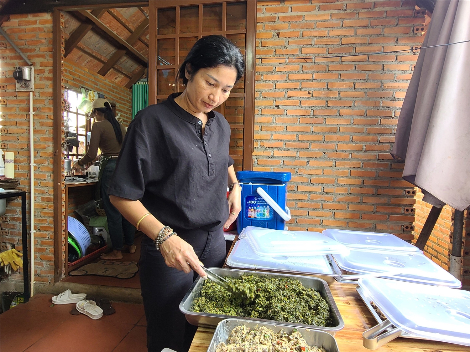 Chị H’Minh Byă, chủ quán Nhà sàn M’Nga Tăng Bi chuẩn bị món ăn truyền thống phục vụ khách du lịch