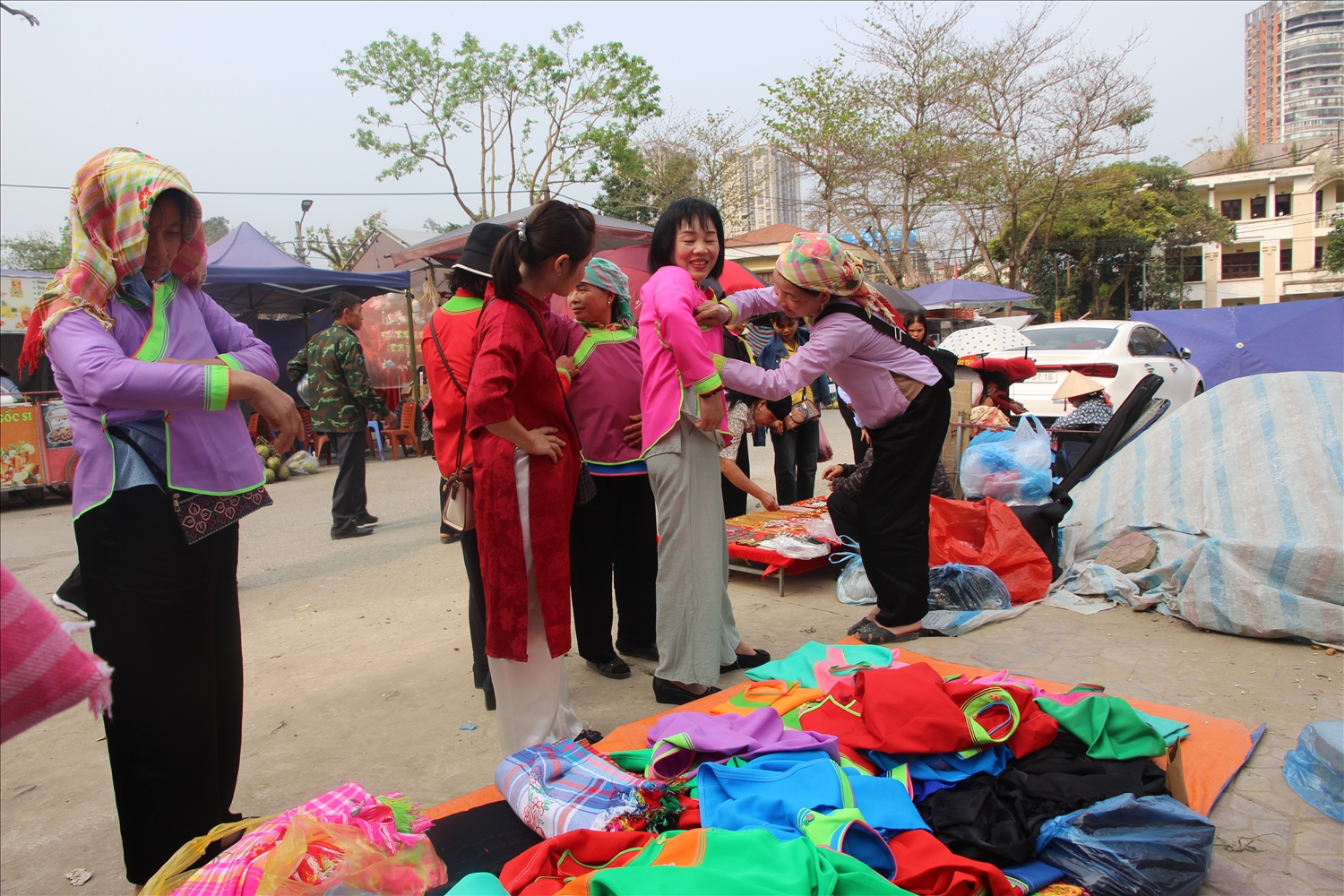 Du khách thích thú trải nghiệm và mua trang phục dân tộc được bày bán tại lễ hội (Ảnh Trọng Bảo)