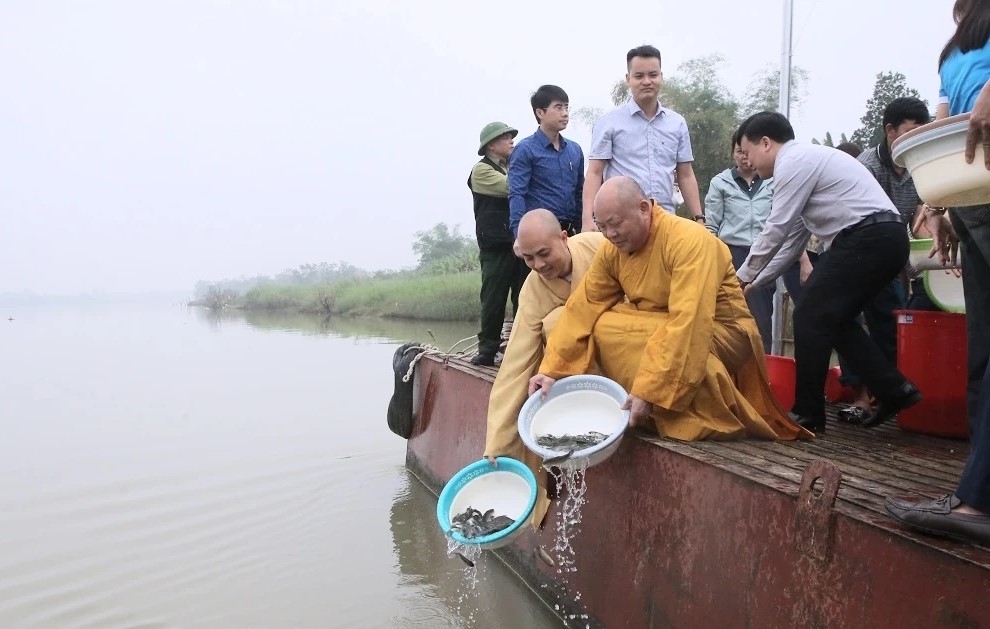 Các đại biểu, tăng ni và Nhân dân tham gia thả cá giống, góp phần tái tạo, phát triển nguồn lợi thủy sản trên lưu vực sông Mã.(Ảnh Lê Hòa)