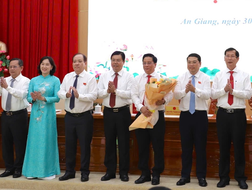 Ông Nguyễn Tiến Hải ( đứng giữa) - Bí thư Tỉnh ủy An Giang tặng hoa chúc mừng ông Hồ Văn Mừng được bầu giữ chức Chủ tịch UBND tỉnh nhiệm kỳ 2026 – 2031