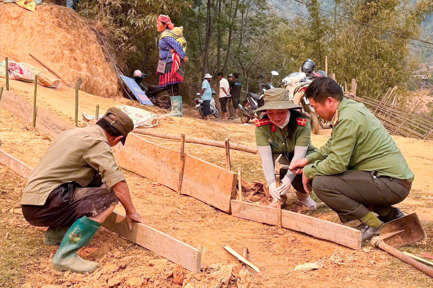 Cán bộ công an xã Mù Cang Chải hướng dẫn người dân lắp đặt ván khuôn