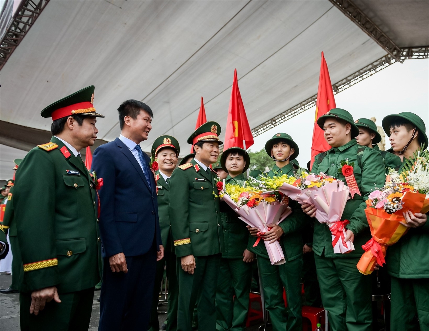 Đại tướng Nguyễn Tân Cương và lãnh đạo tỉnh Ninh Bình tặng hoa chúc mừng, động viên các thanh niên tích cực phấn đấu, rèn luyện trong môi trường quân ngũ.(Ảnh CTV)