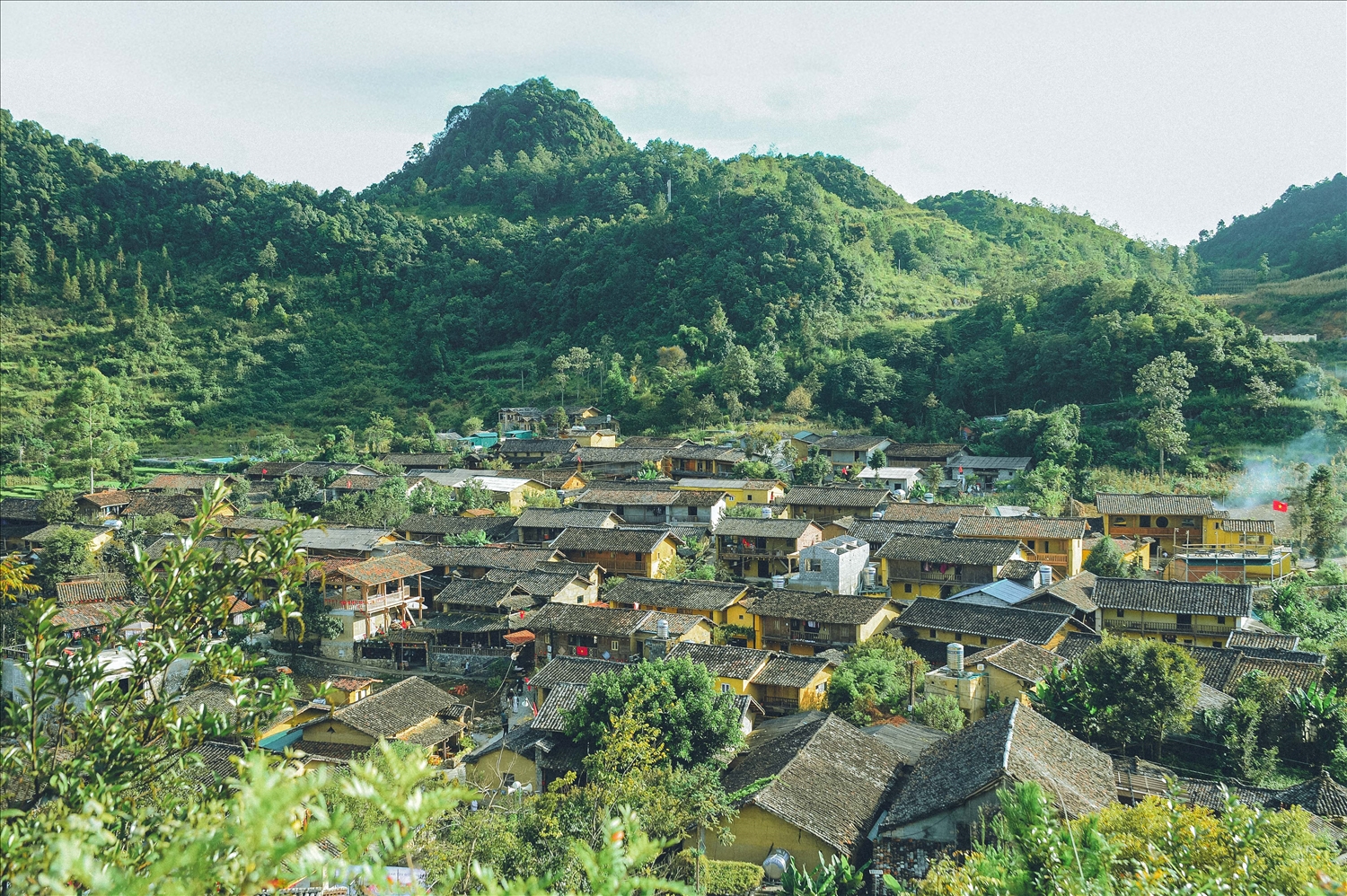 Làng Lô Lô Chải nép mình dưới chân Cột cờ Lũng Cú, nổi bật với những ngôi nhà trình tường mái ngói âm dương và sắc màu trang phục truyền thống rực rỡ của đồng bào Lô Lô
