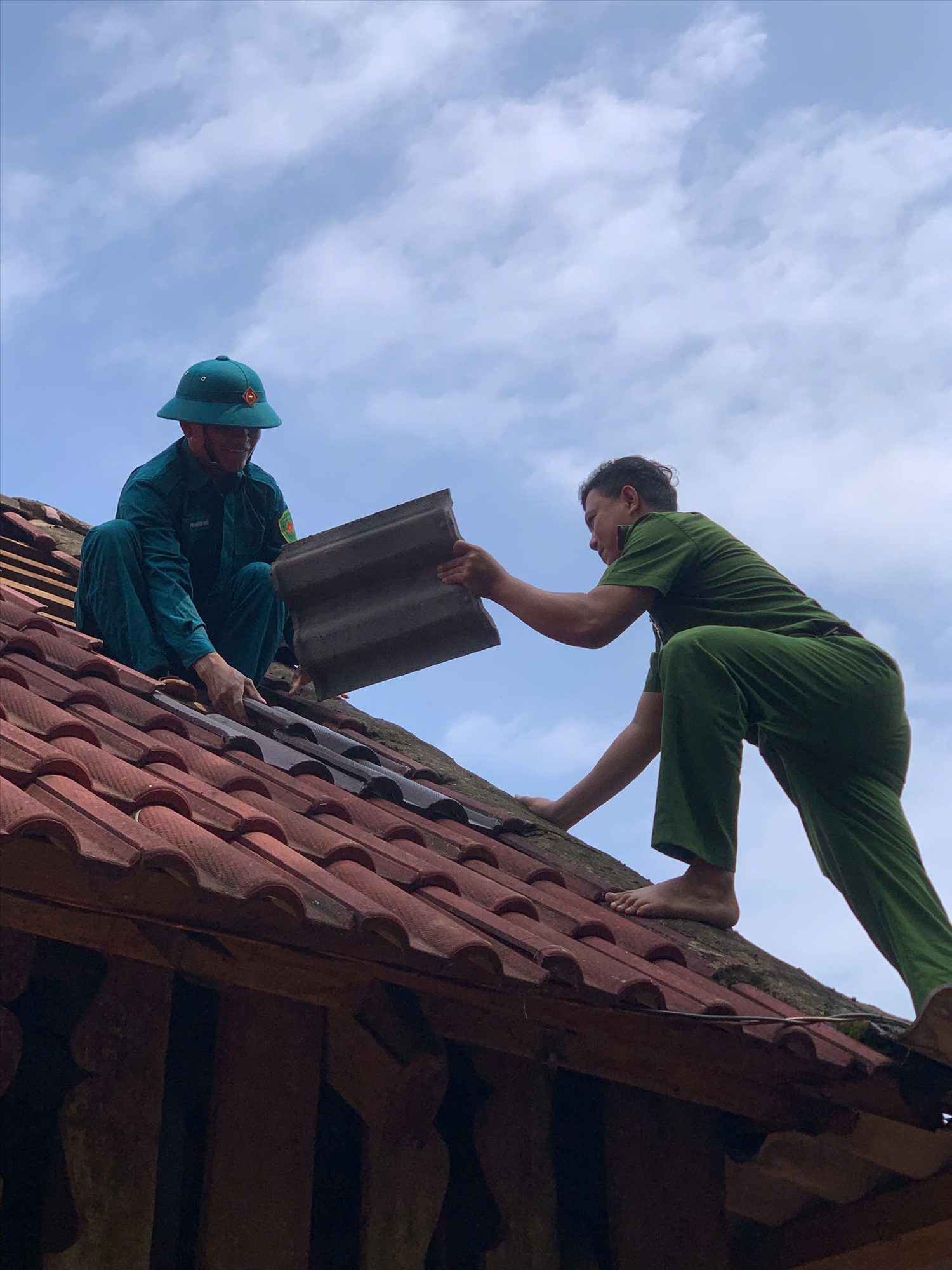 Lực lượng chức năng hỗ trợ người dân sửa chữa nhà cửa bị hư hại do lốc xoáy. (Ảnh PL)