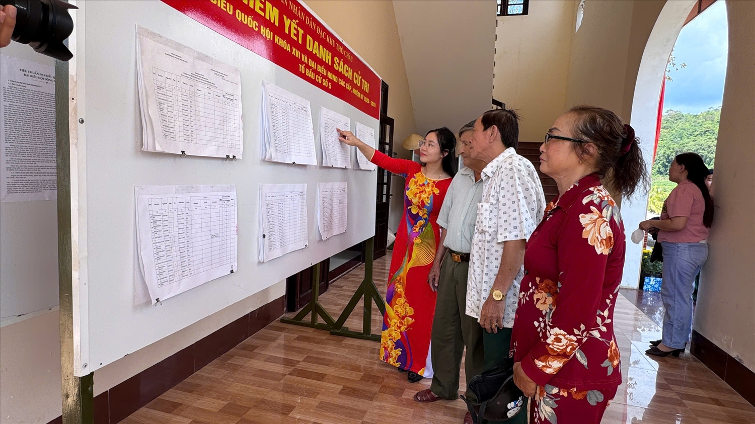 Các cử tri xem danh sách được niêm yết công khai trước các điểm bầu cử 