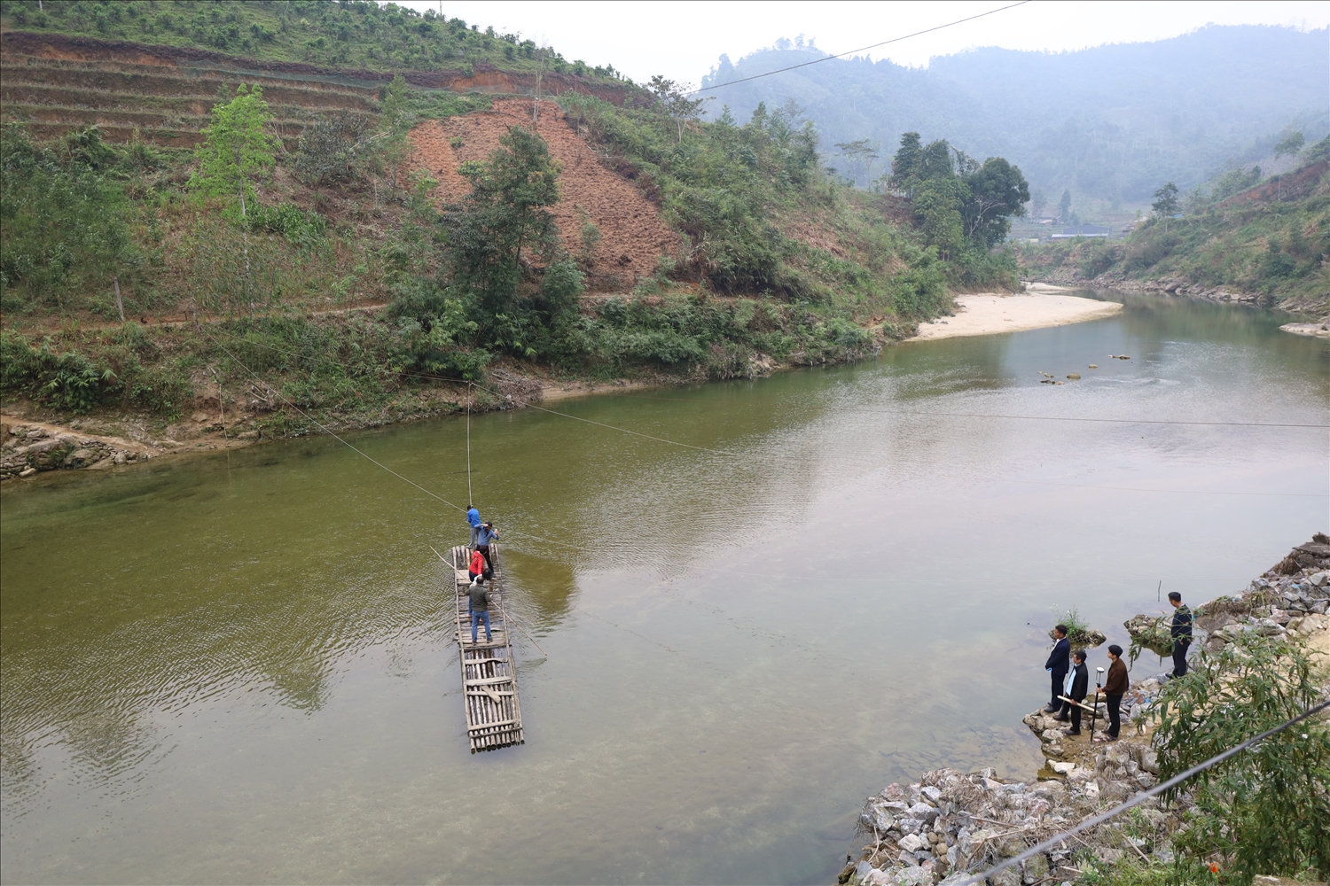 Từ nhiều năm nay, người dân và các em học sinh thôn Minh Sơn phải dùng bè, mảng để qua suối