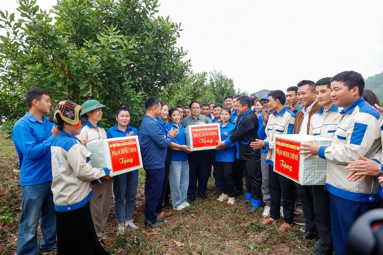 Thủ tướng Chính phủ Phạm Minh Chính tặng quà, biểu dương các hộ dân tiêu biểu trong sản xuất cây mắc ca, phát triển kinh tế hộ gia đình - Ảnh: VGP/Nhật Bắc