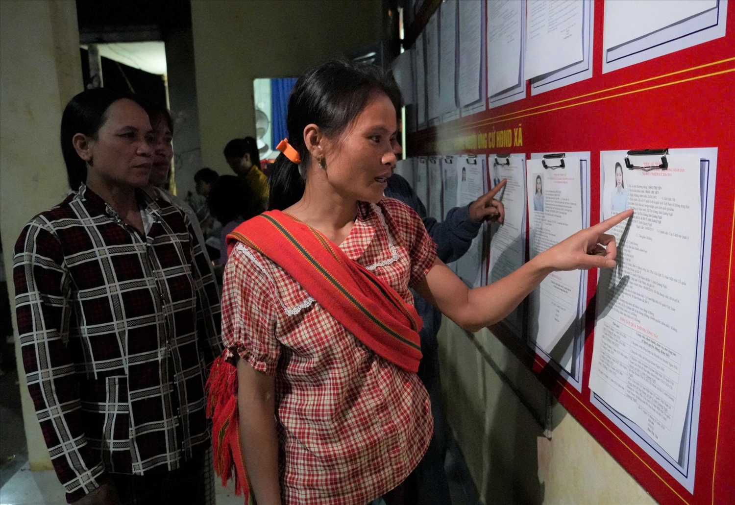 Đồng bào DTTS ở thôn Kon Khôn tranh thủ buổi tối đến nhà văn hóa tìm hiểu về tiểu sử các ứng cử viên đại biểu Quốc hội và đại biểu HĐND các cấp. (Ảnh: Ngọc Chí)