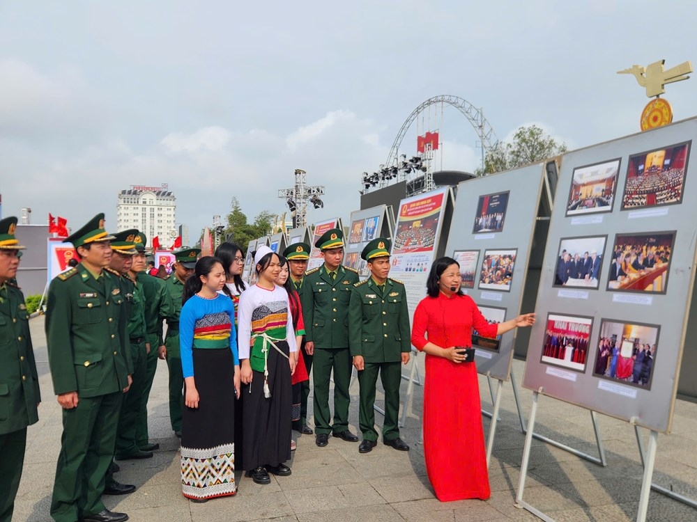 Đại biểu và các em học sinh tham quan tranh, ảnh tại triển lãm.