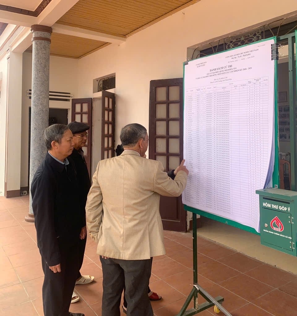 Người dân xã Hồ Vương theo dõi danh sách cử tri được niêm yết tại tổ bầu cử.